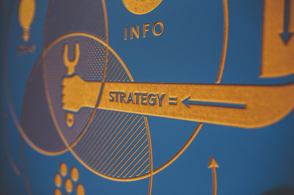 graphic of arm holding wrench with the word strategy across it